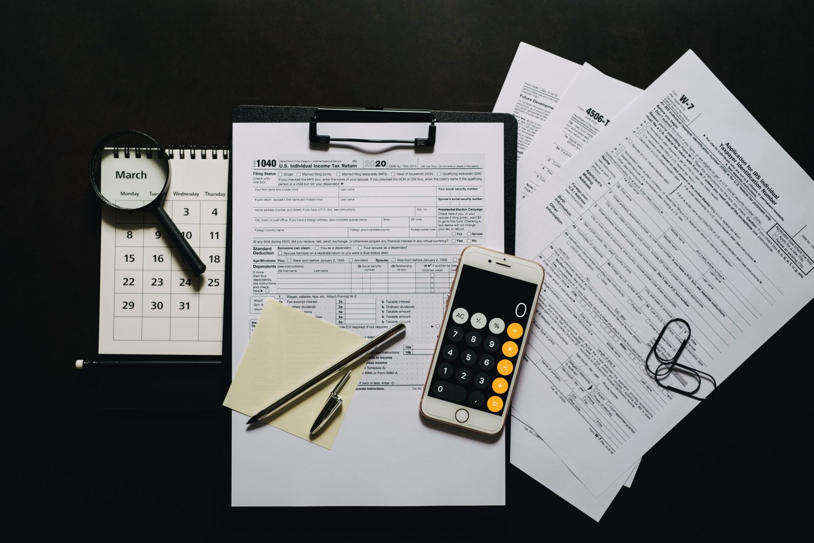 Tax documents, calculator, magnifying glass, and calendar on a desk, representing UAE free zone corporate tax registration and EmaraTax filing preparation