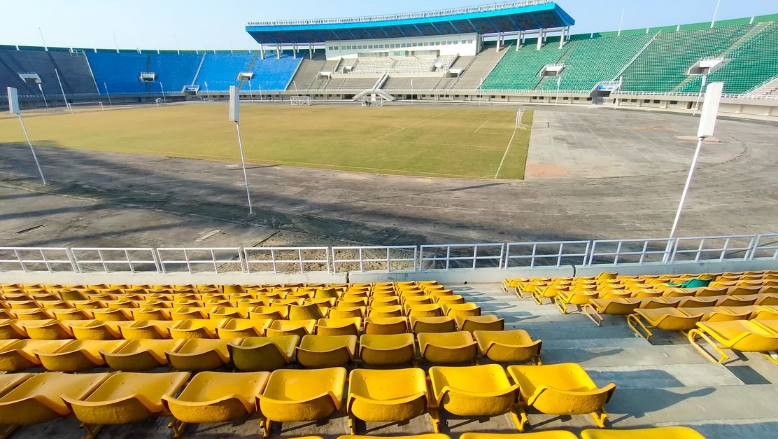 Empty stadium with colorful seating, representing UAE sports entities and Corporate Tax exemption compliance