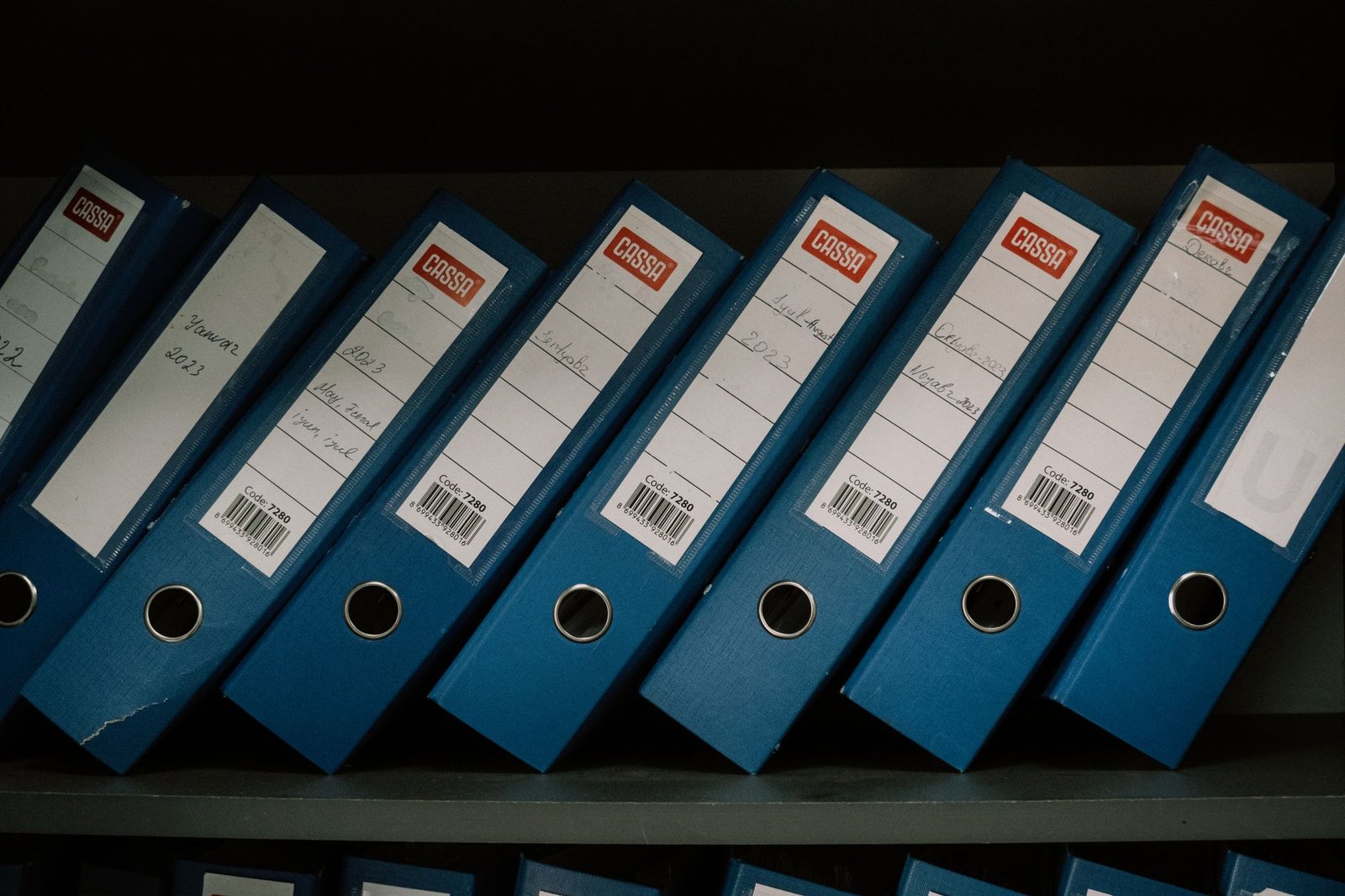 Neatly arranged blue office binders labeled with dates, representing UAE corporate tax record keeping and document retention