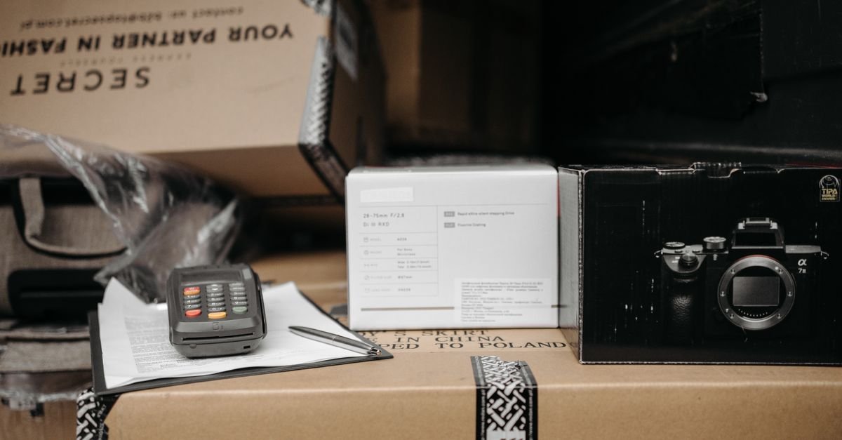 Packed online marketplace order boxes with a payment terminal and invoice, representing UAE e-commerce VAT and Corporate Tax compliance for online sellers