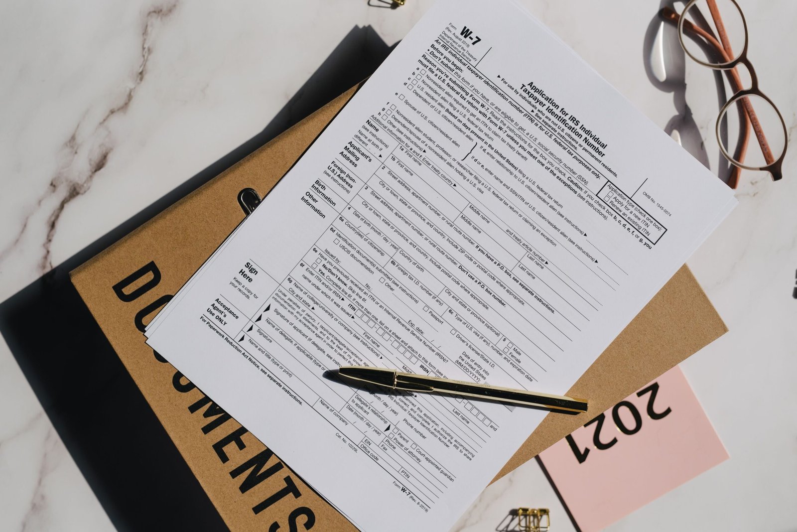 Tax form with pen and eyeglasses on a desk, representing UBO declaration and compliance filing in the UAE