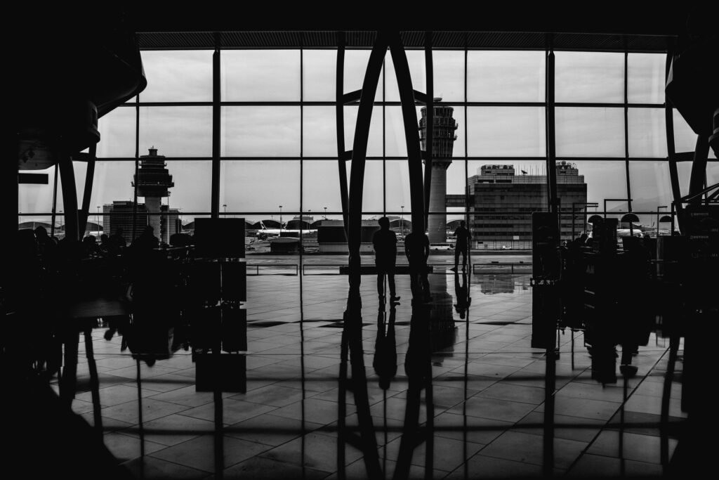 Travellers silhouetted against large airport terminal windows, representing an airport free zone company setup