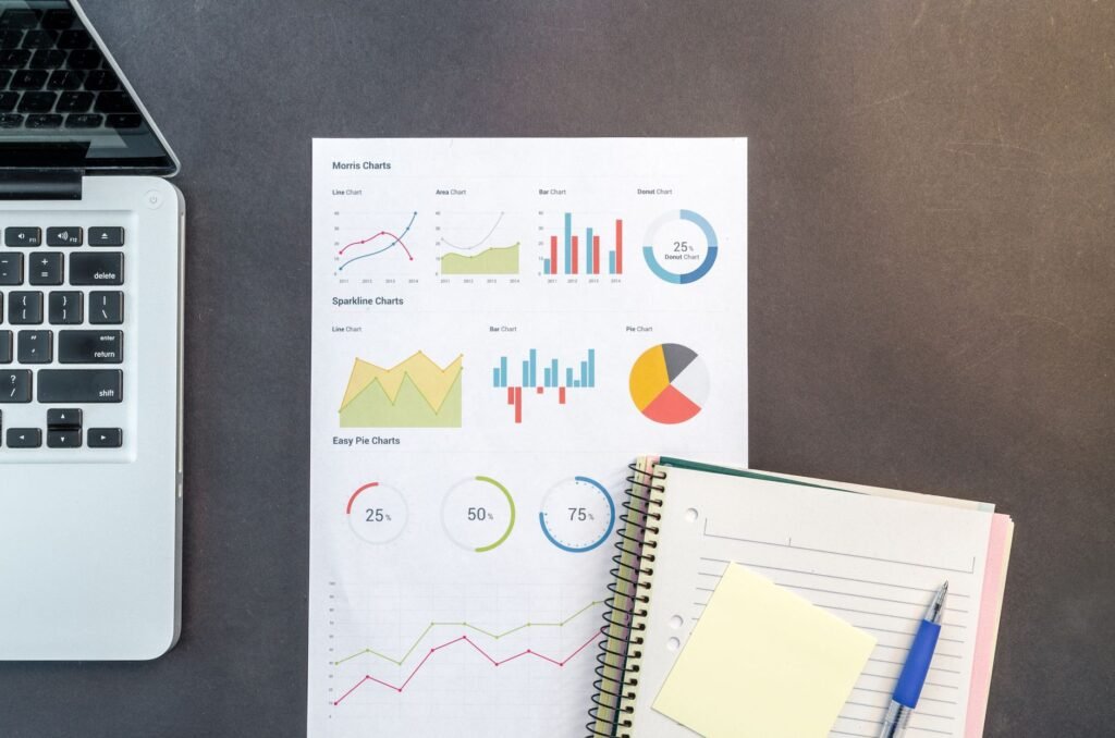 Desk with financial charts, a laptop and notebooks for tax and accounting analysis
