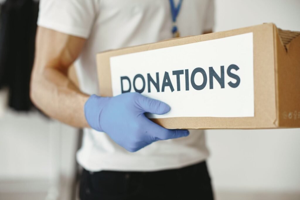 Person holding a cardboard box labelled Donations, illustrating company donations and charitable contributions under UAE Corporate Tax